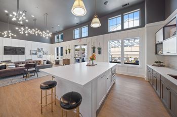 A kitchen with a white countertop and a bar stool.